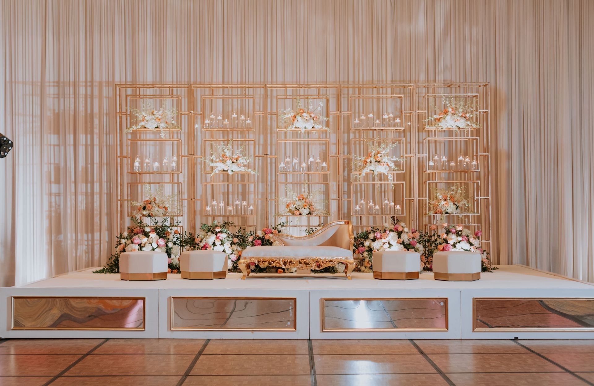 A stage decorated with flowers and candles for a wedding reception.