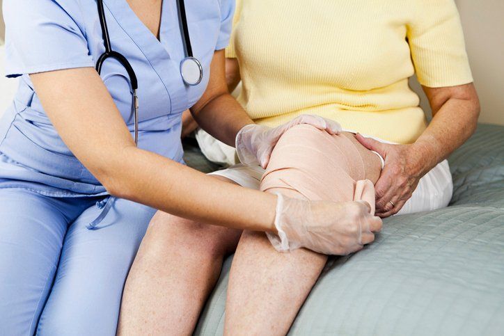 Female nurse bandaging patient's knee – Alfredton, VIC – Ballarat Nurses