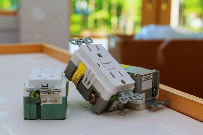 Two electrical outlets are sitting on top of each other on a table.