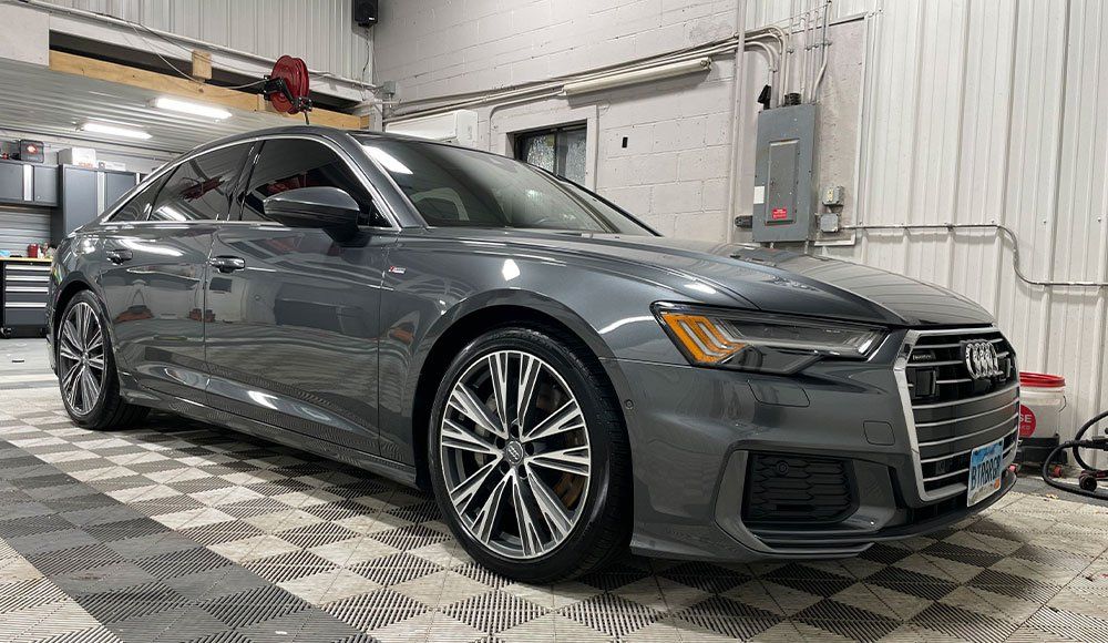 A gray audi a6 is parked in a garage.