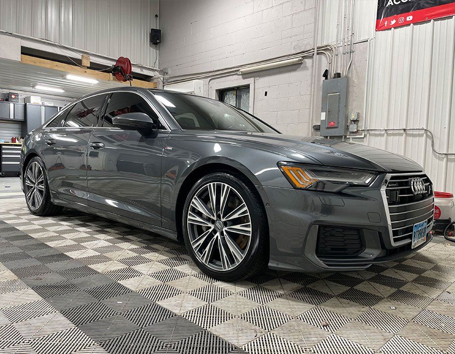 A gray audi a6 is parked in a garage.