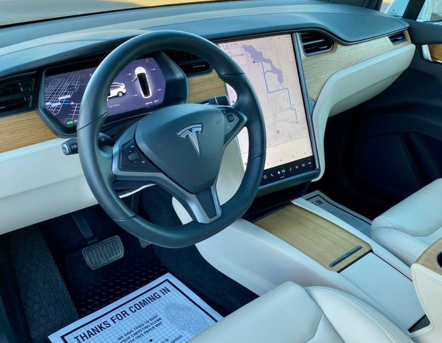 The interior of a tesla model x with a steering wheel