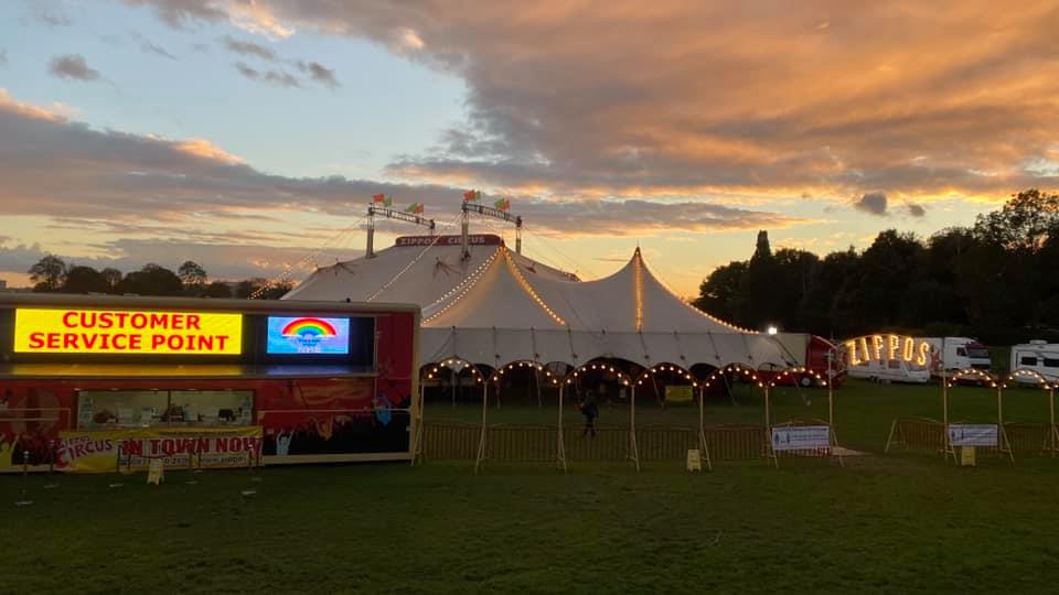 A large white tent is sitting in the middle of a field.