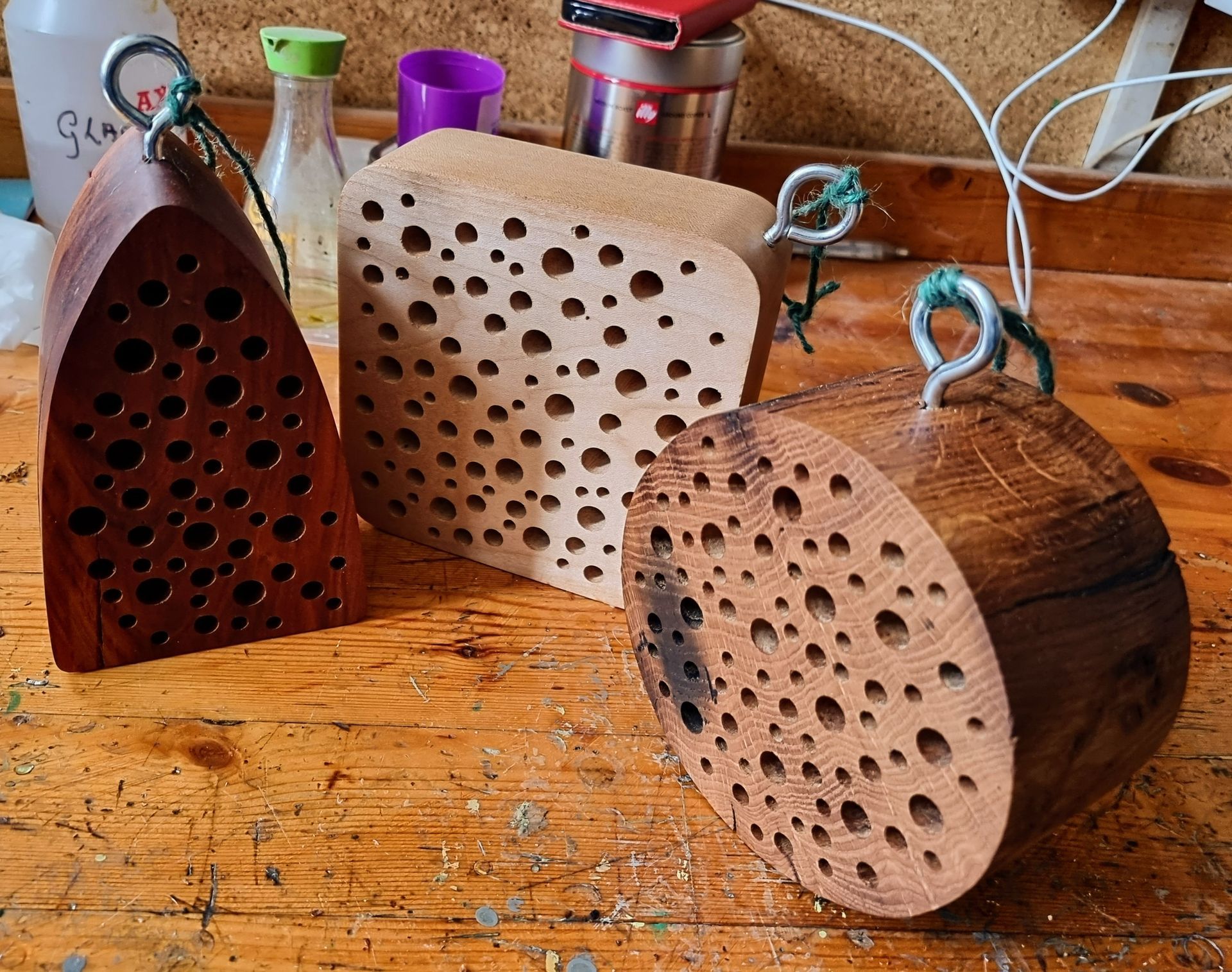Three wooden blocks with holes in them are sitting on a wooden table.