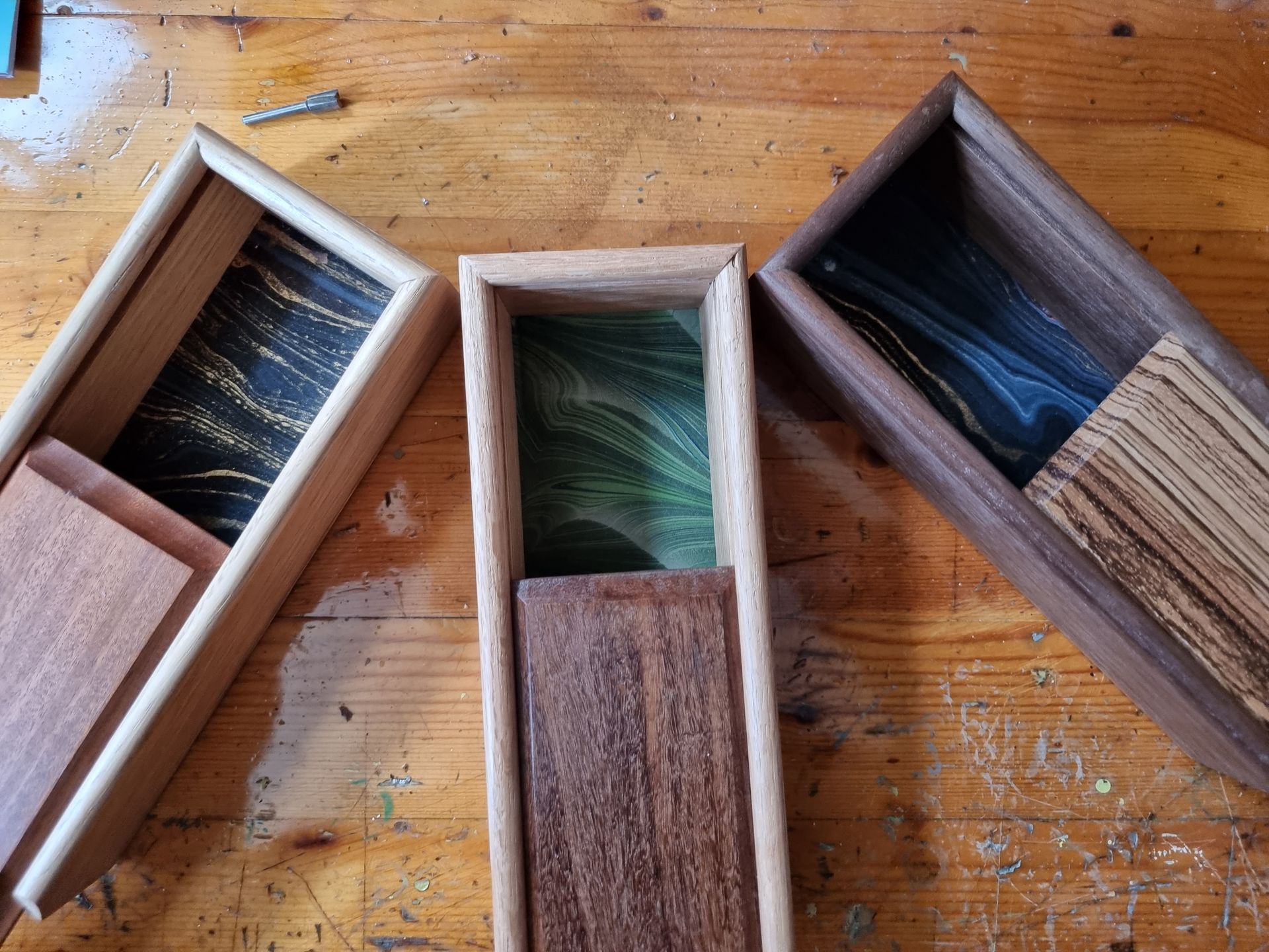Three wooden boxes are sitting on a wooden table