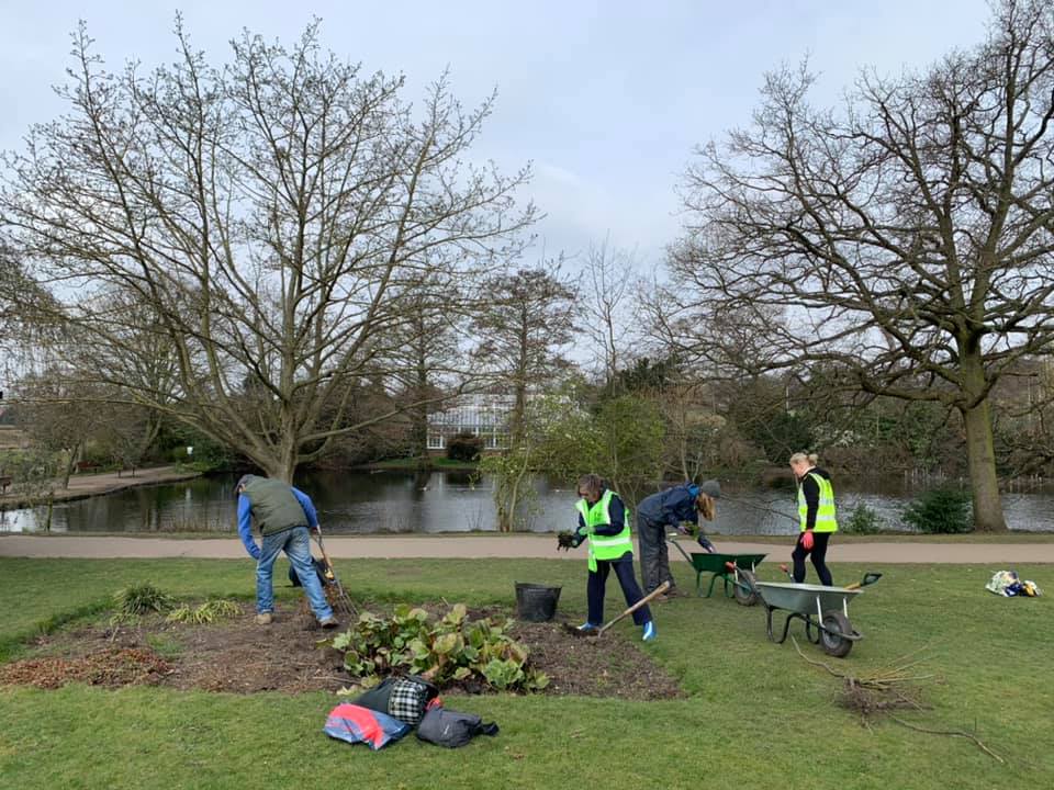 A group of people are working in a park.