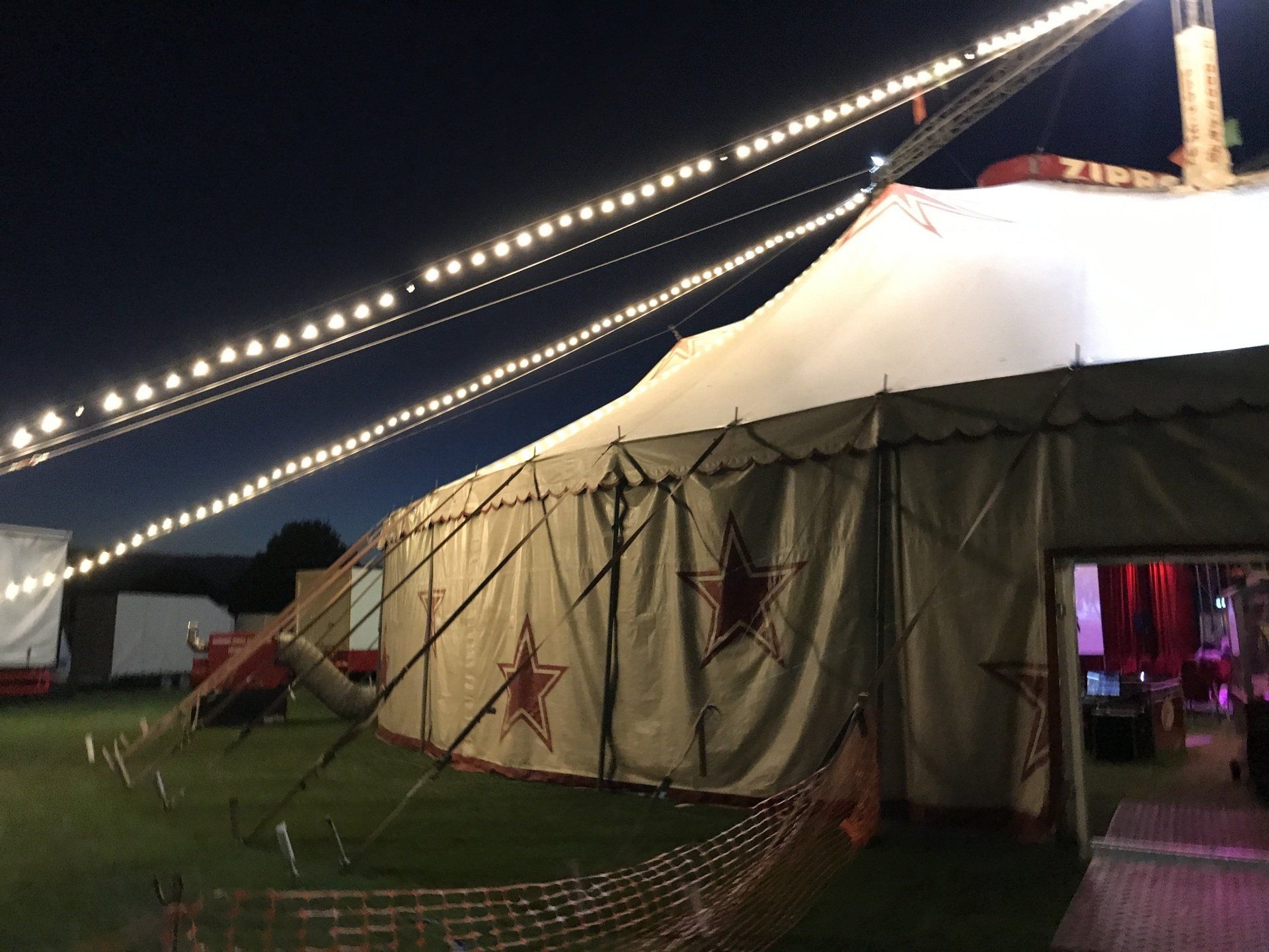 A large circus tent is lit up at night.