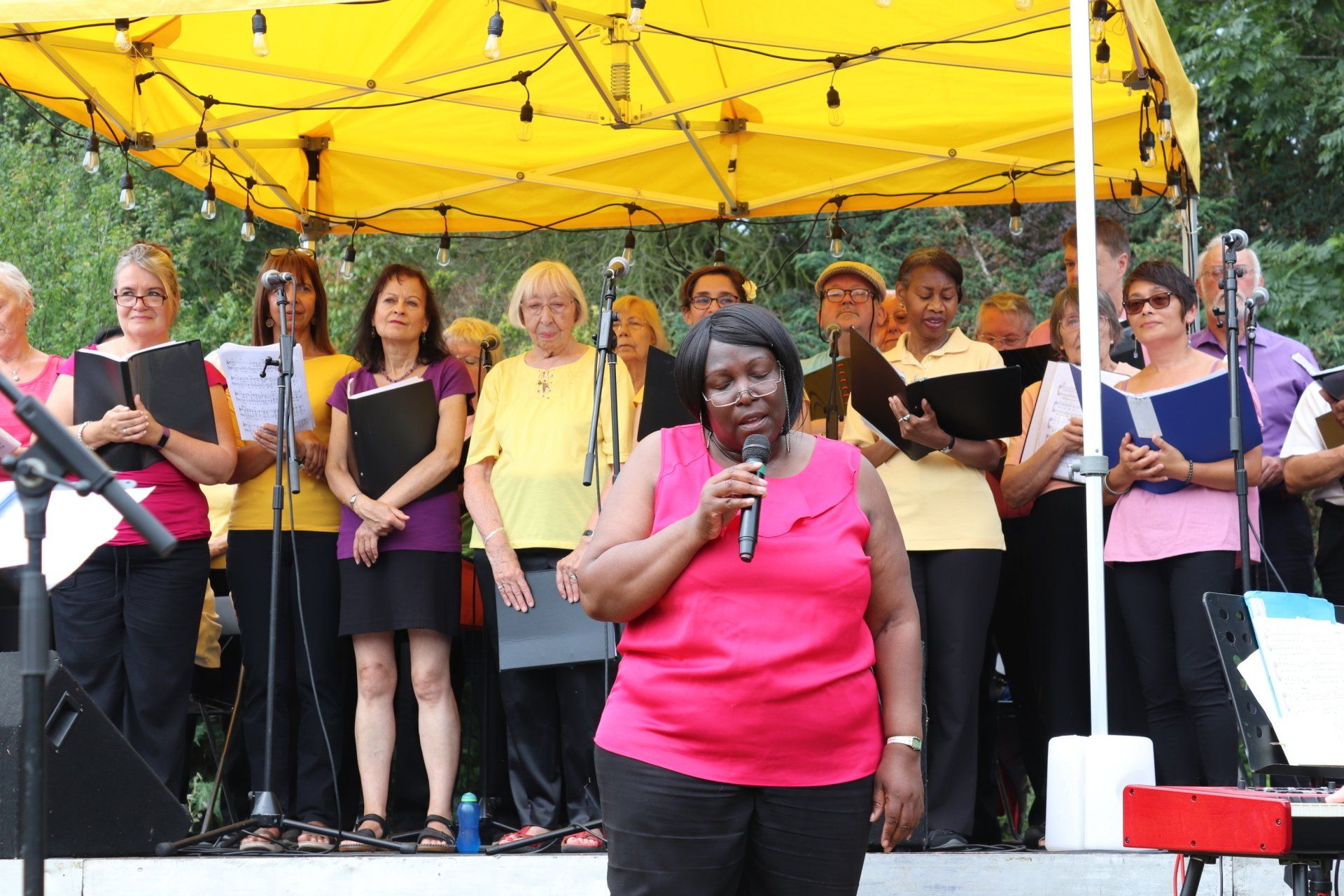 A woman singing into a microphone in front of a choir