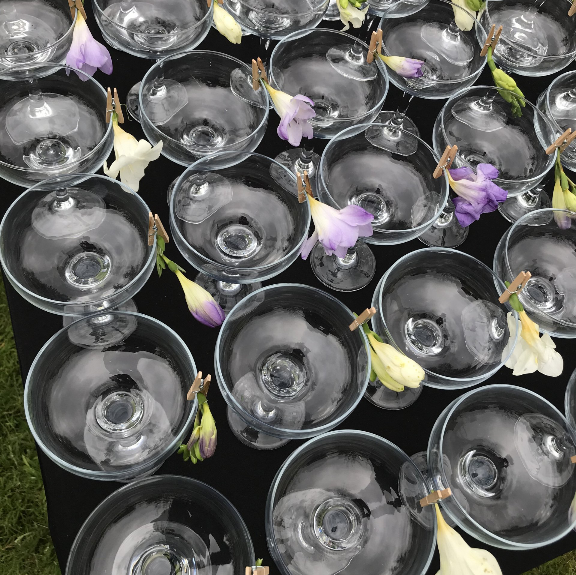 A bunch of wine glasses with flowers in them