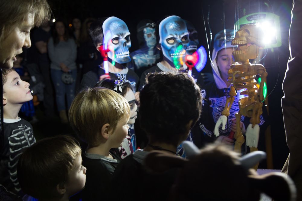 A group of people are looking at a skeleton in a dark room.