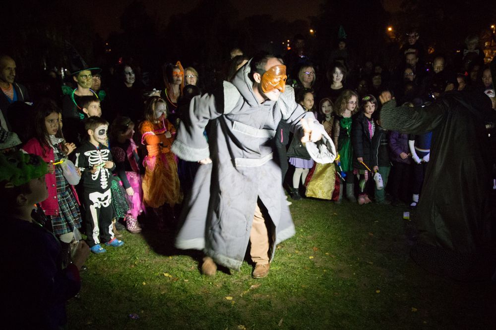 A man in a mask is dancing in front of a crowd of people.
