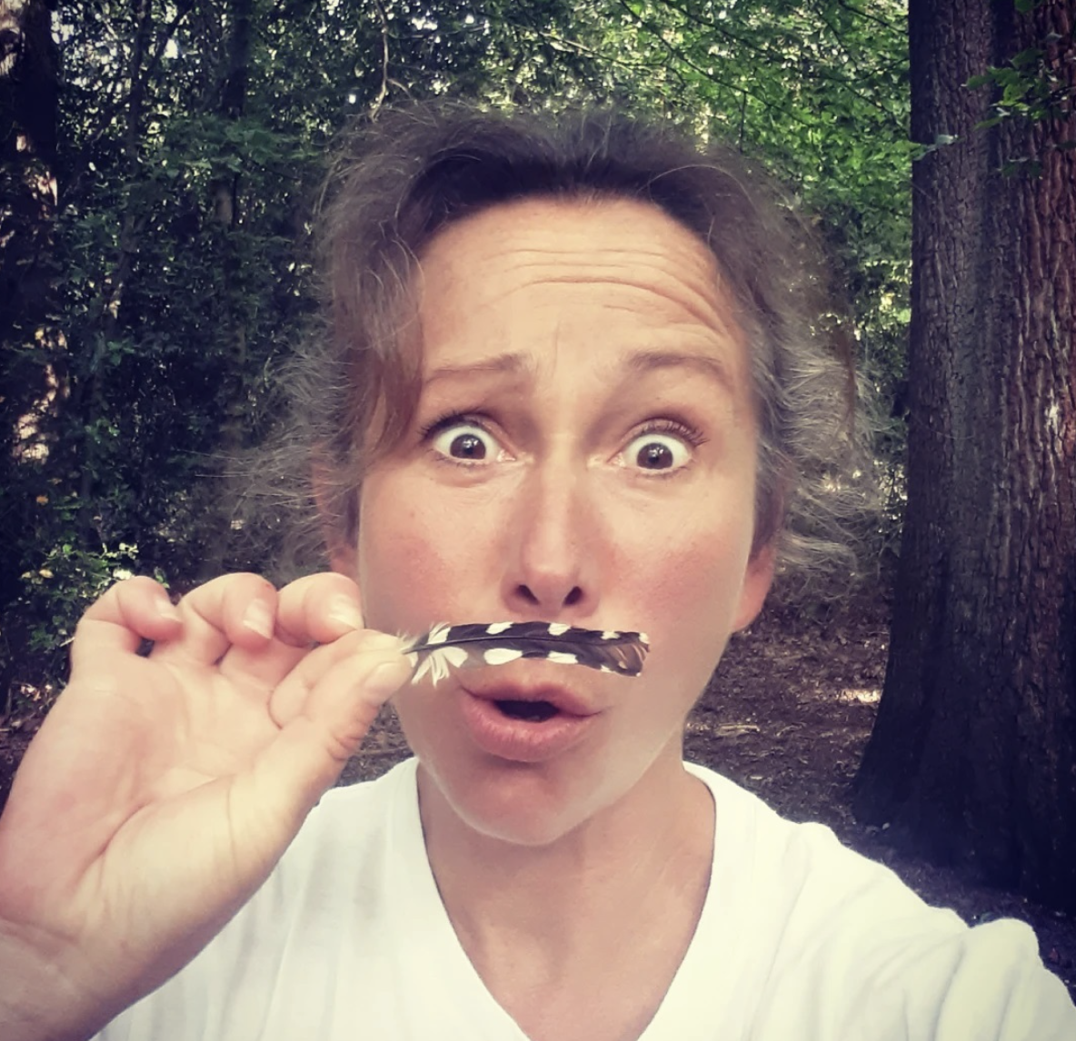 A woman with a flower in her mouth making a funny face