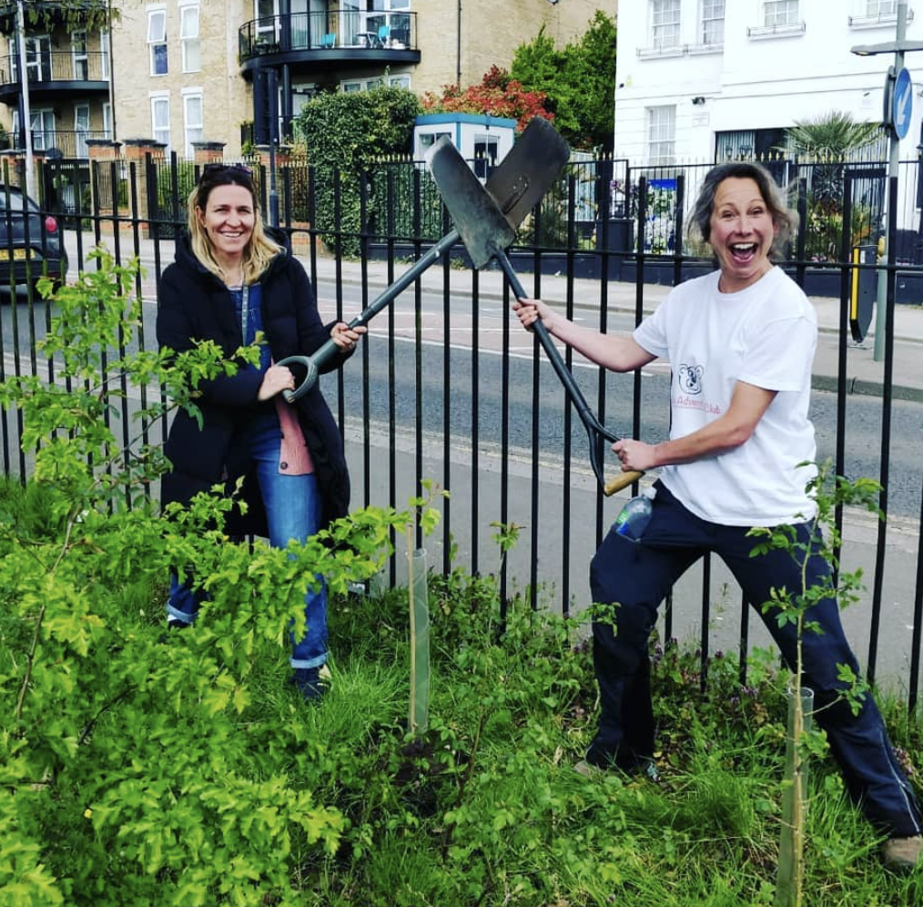 two people are standing next to each other holding shovels