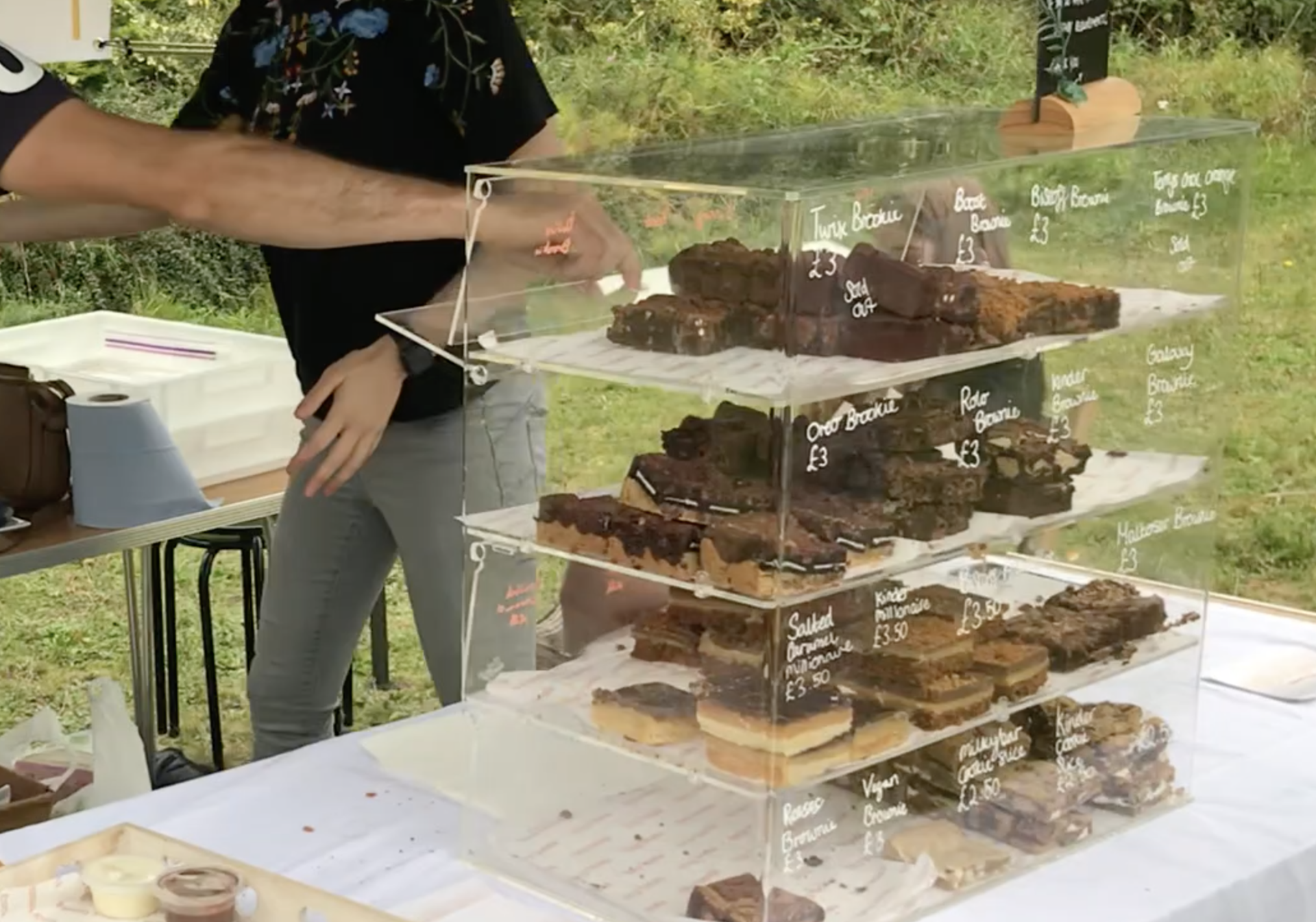 A man is standing in front of a display case of food.