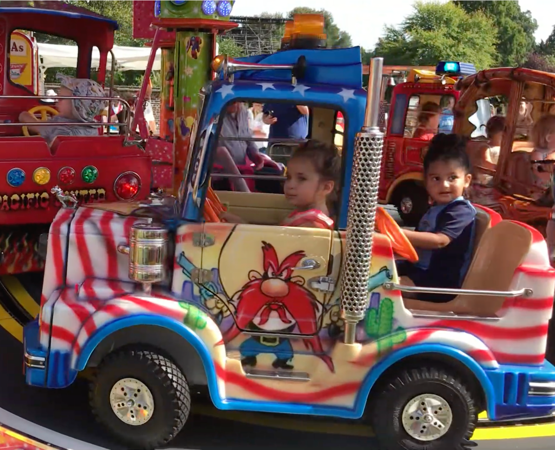A pink tent with candy floss on it is sitting on a sidewalk.