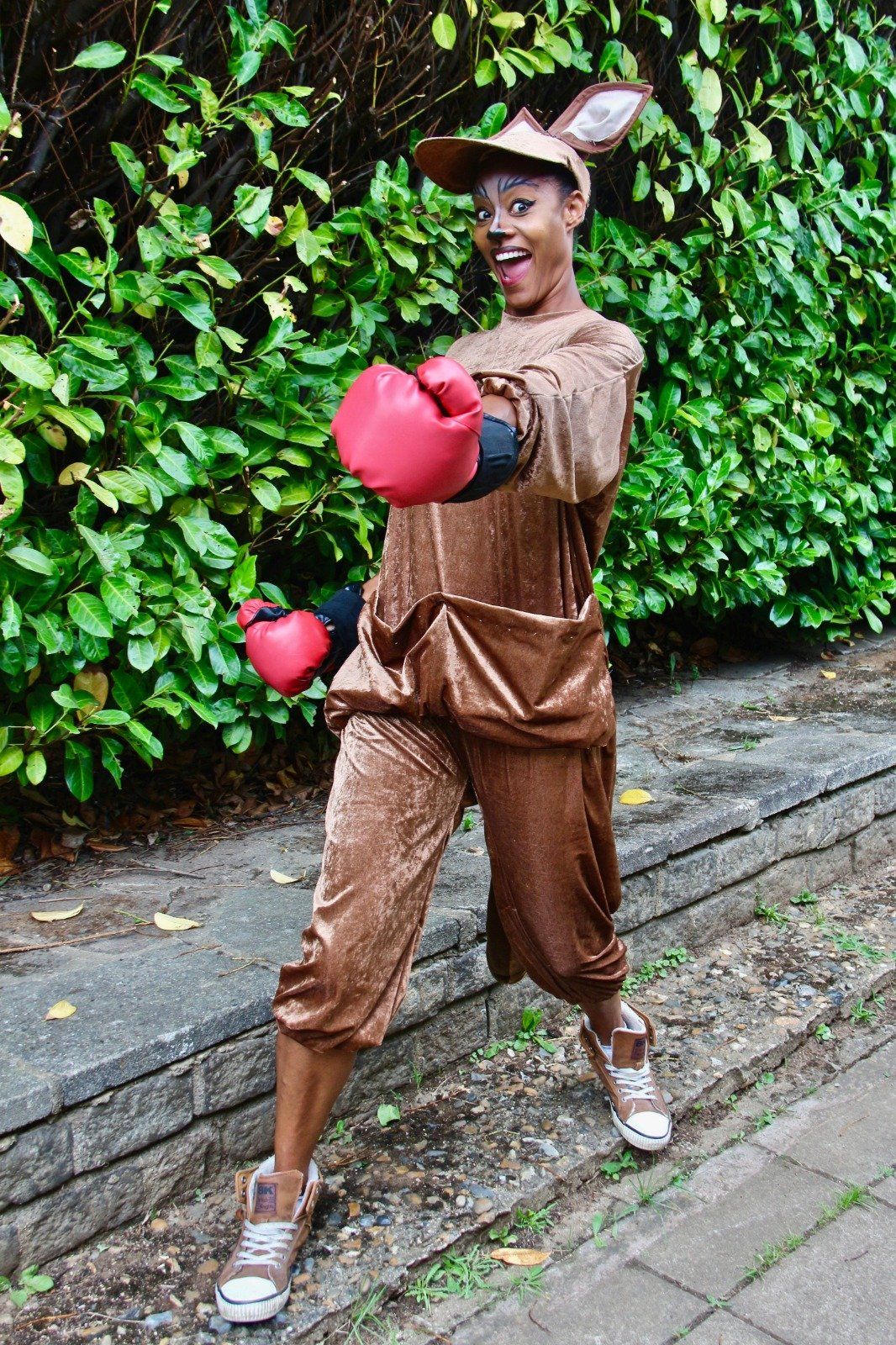 A person in a kangaroo costume is wearing red boxing gloves.