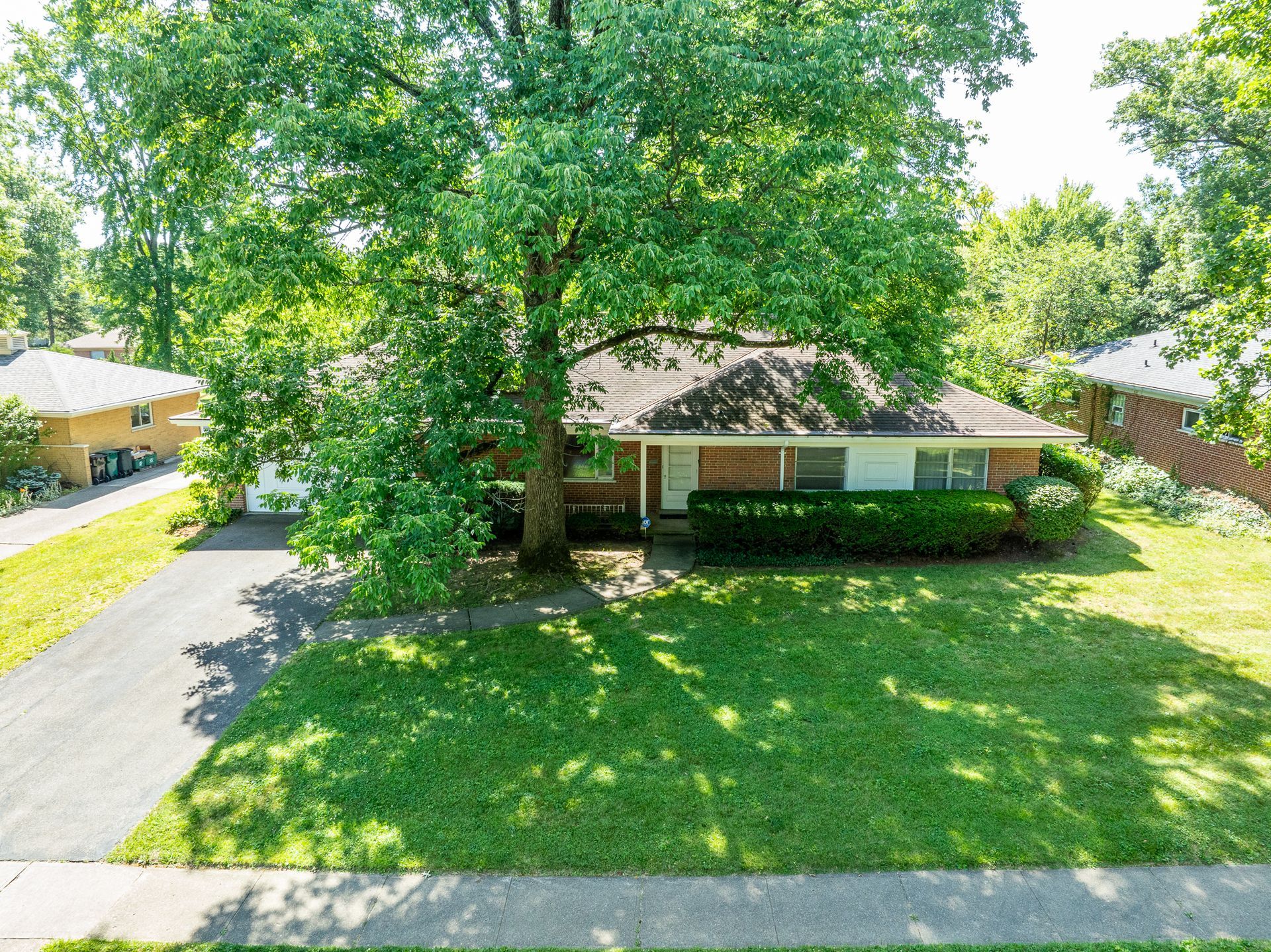 A dining room with a table and chairs and a wooden staircase.