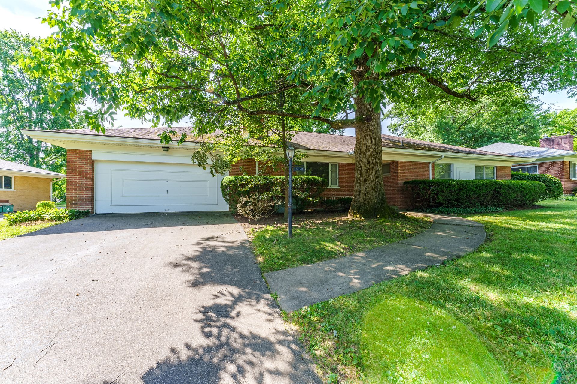 A living room with a couch , chairs , ottoman and a mirror