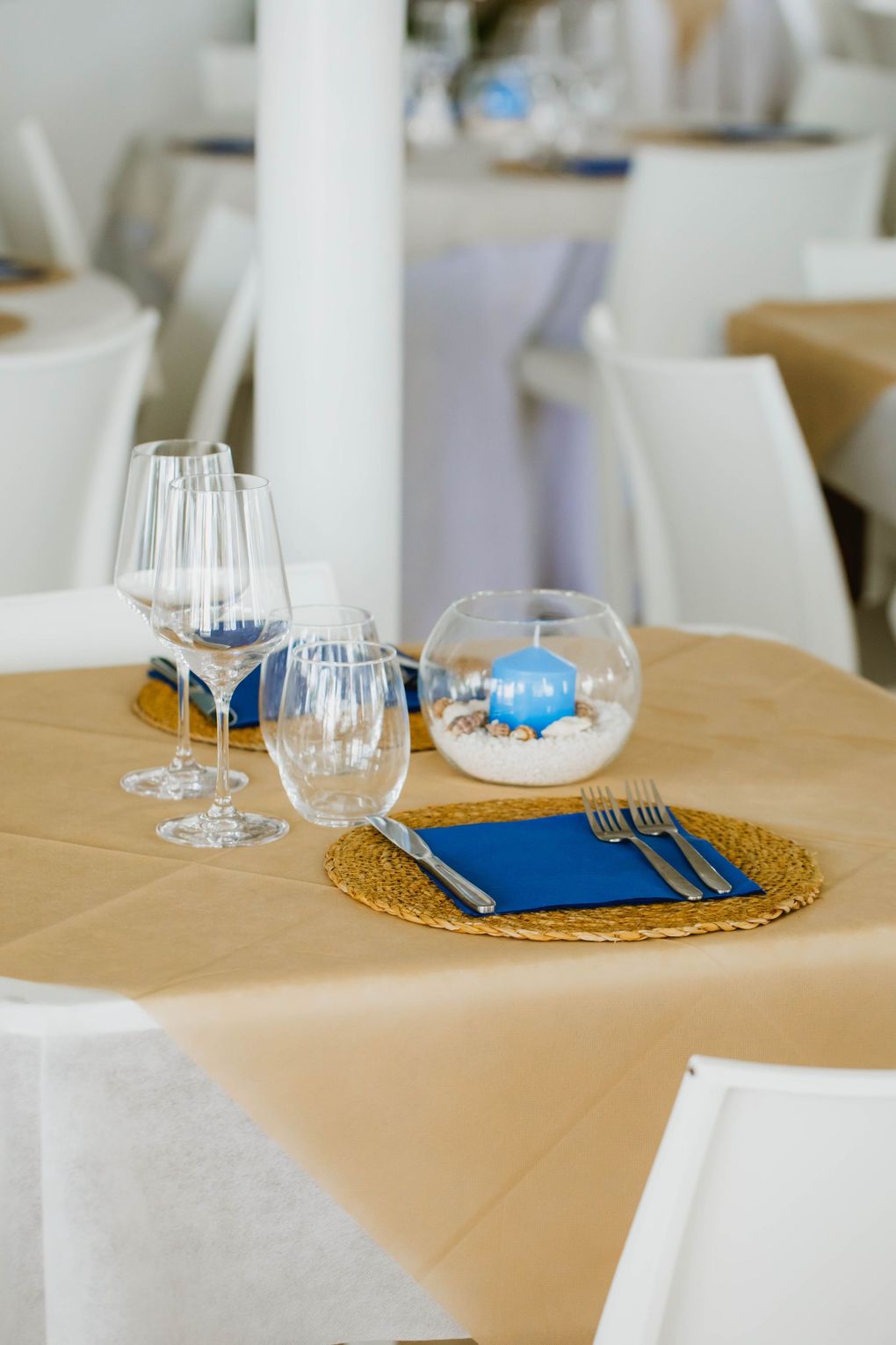 Un tavolo in un ristorante con bicchieri, posate e un vaso sopra.
