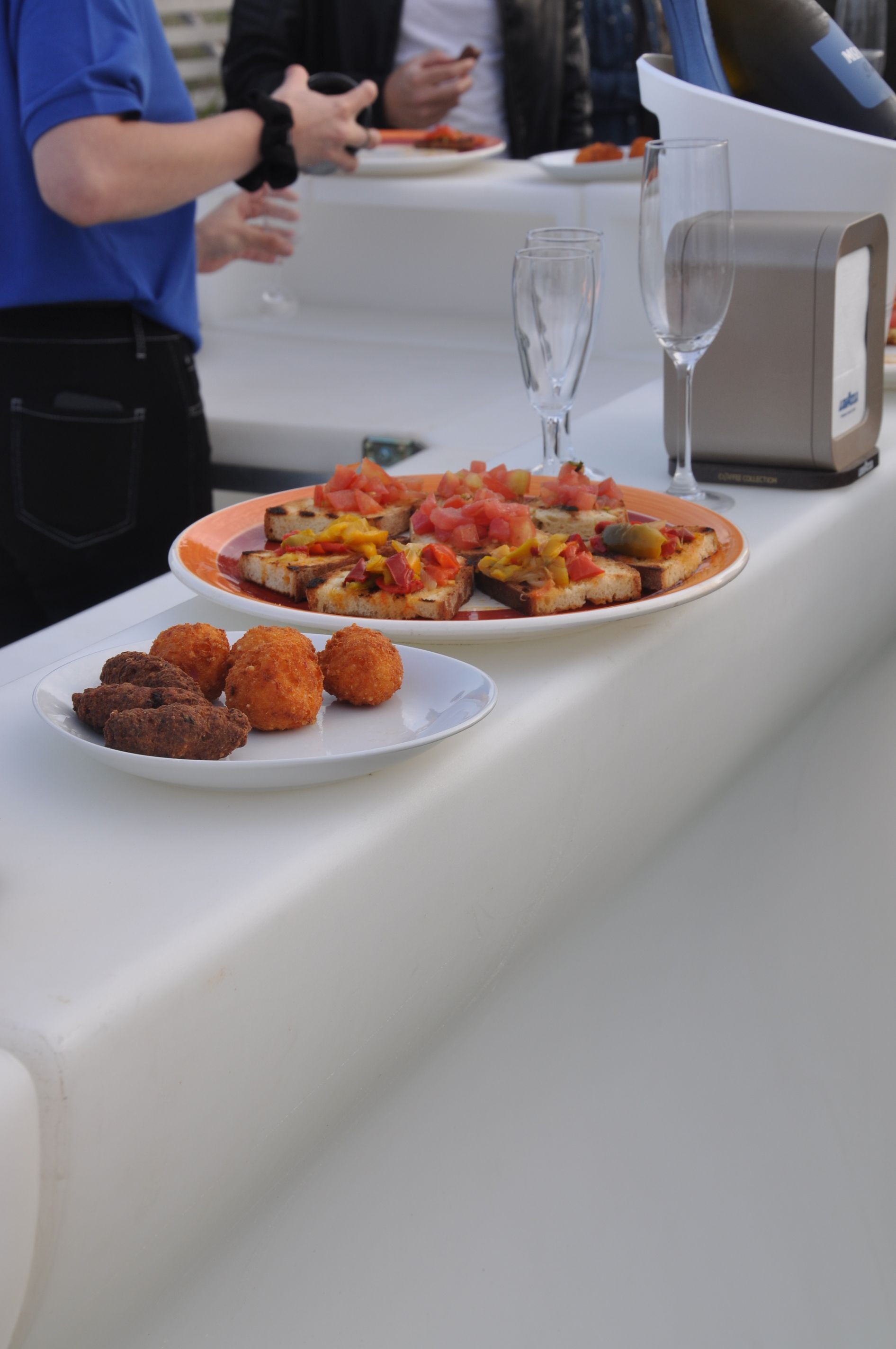 Un piatto di cibo è appoggiato su un bancone accanto a un bicchiere di vino