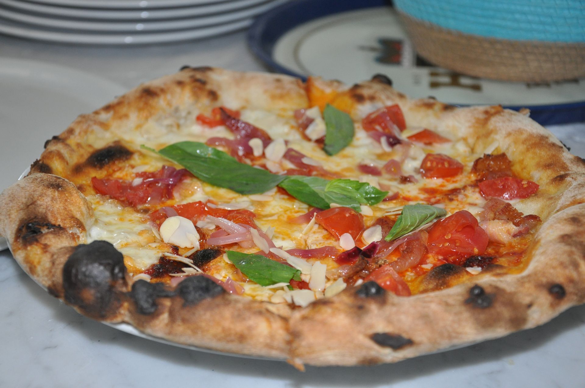 Una pizza con tanti condimenti è su un piatto su un tavolo.