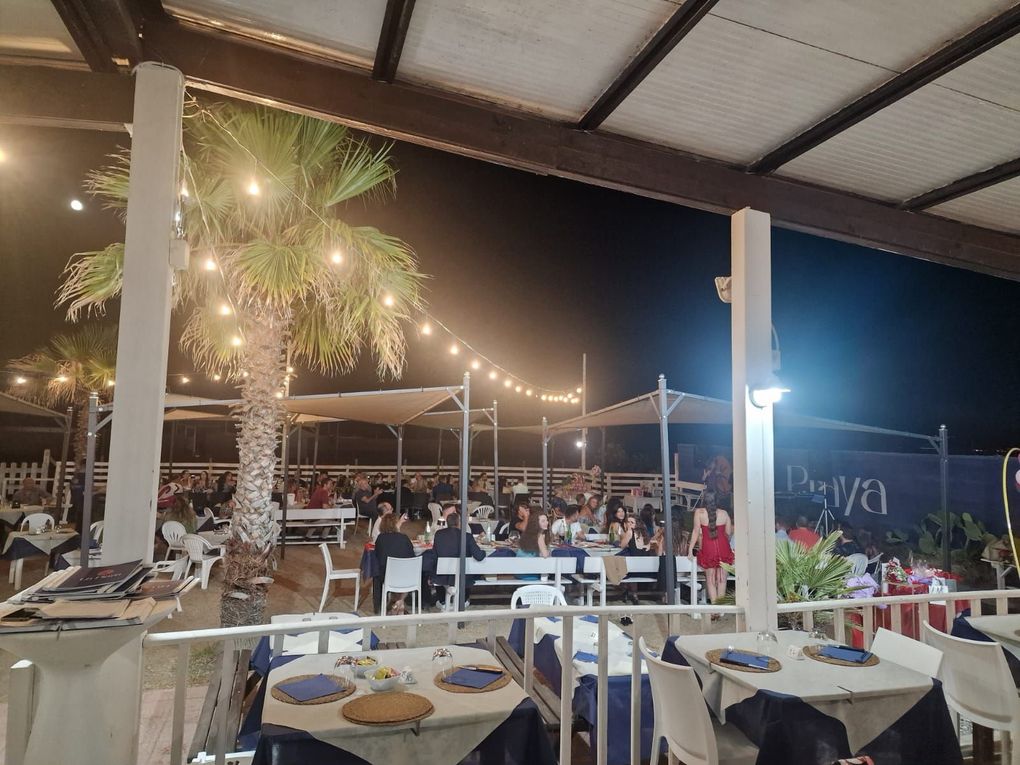 Un tavolo in un ristorante con bicchieri, posate e un vaso sopra.