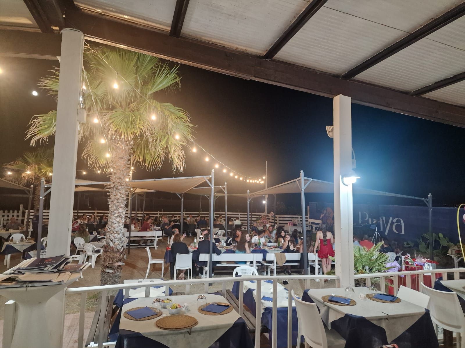 Un tavolo in un ristorante con bicchieri, posate e un vaso sopra.