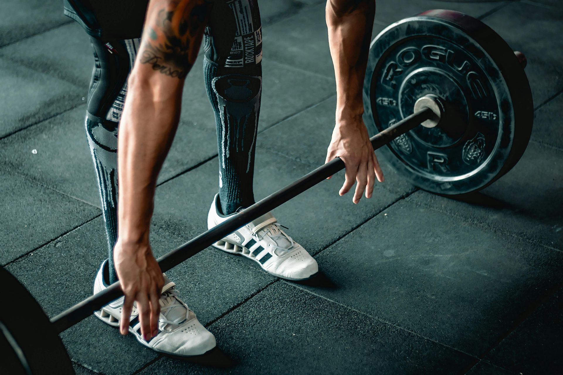 A man is lifting a barbell in a gym.