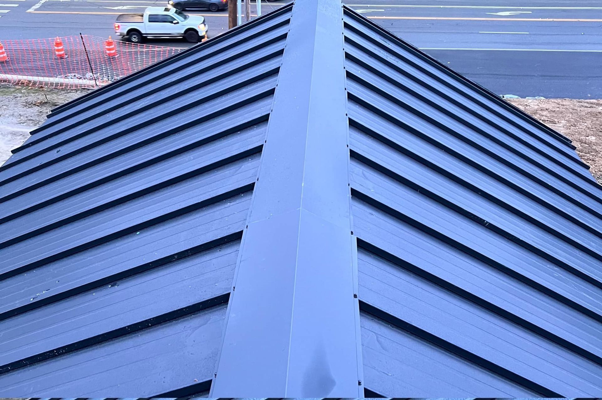 A blue roof with a white truck parked in the background