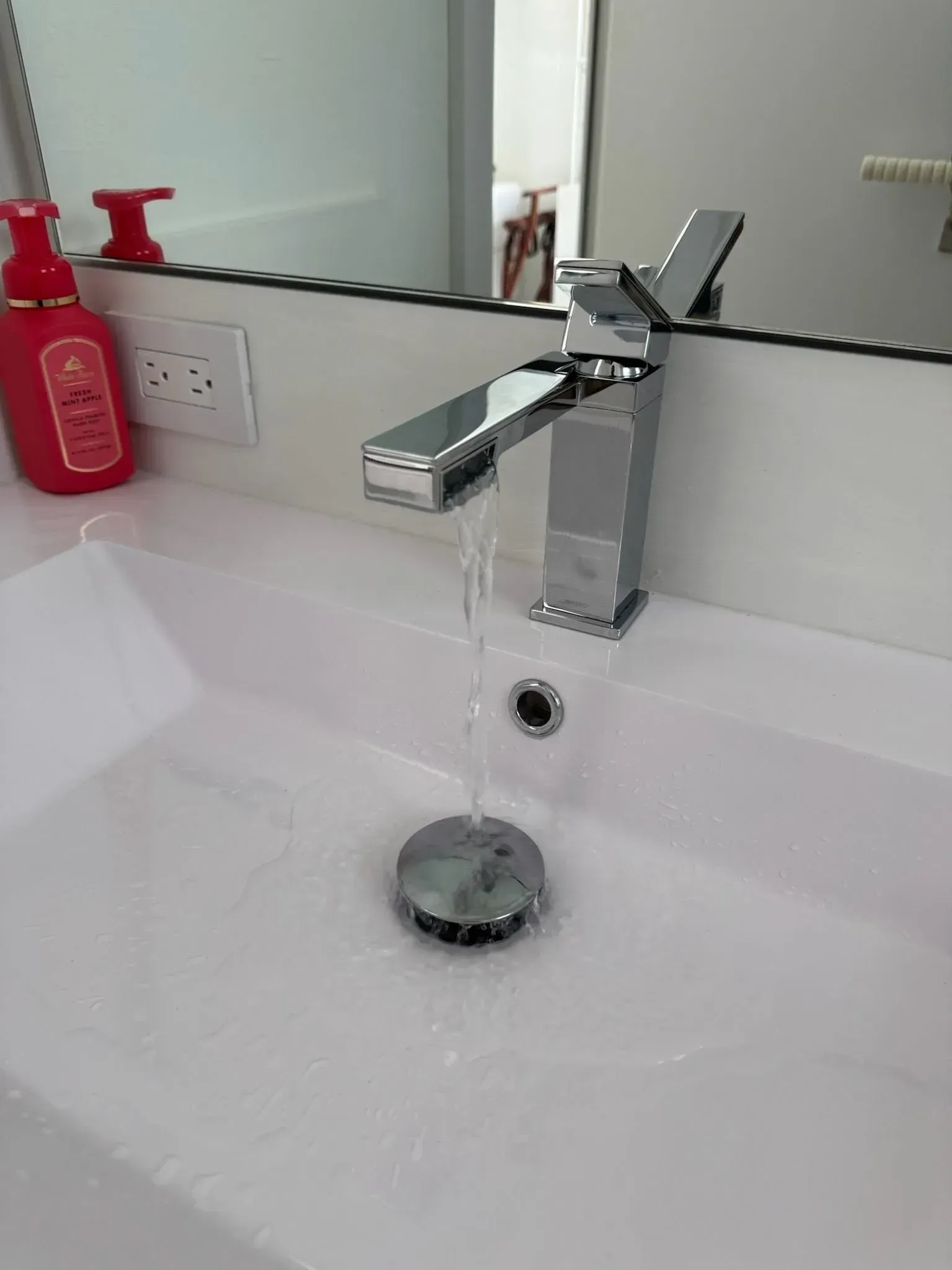 A bathroom sink with a faucet and a soap dispenser