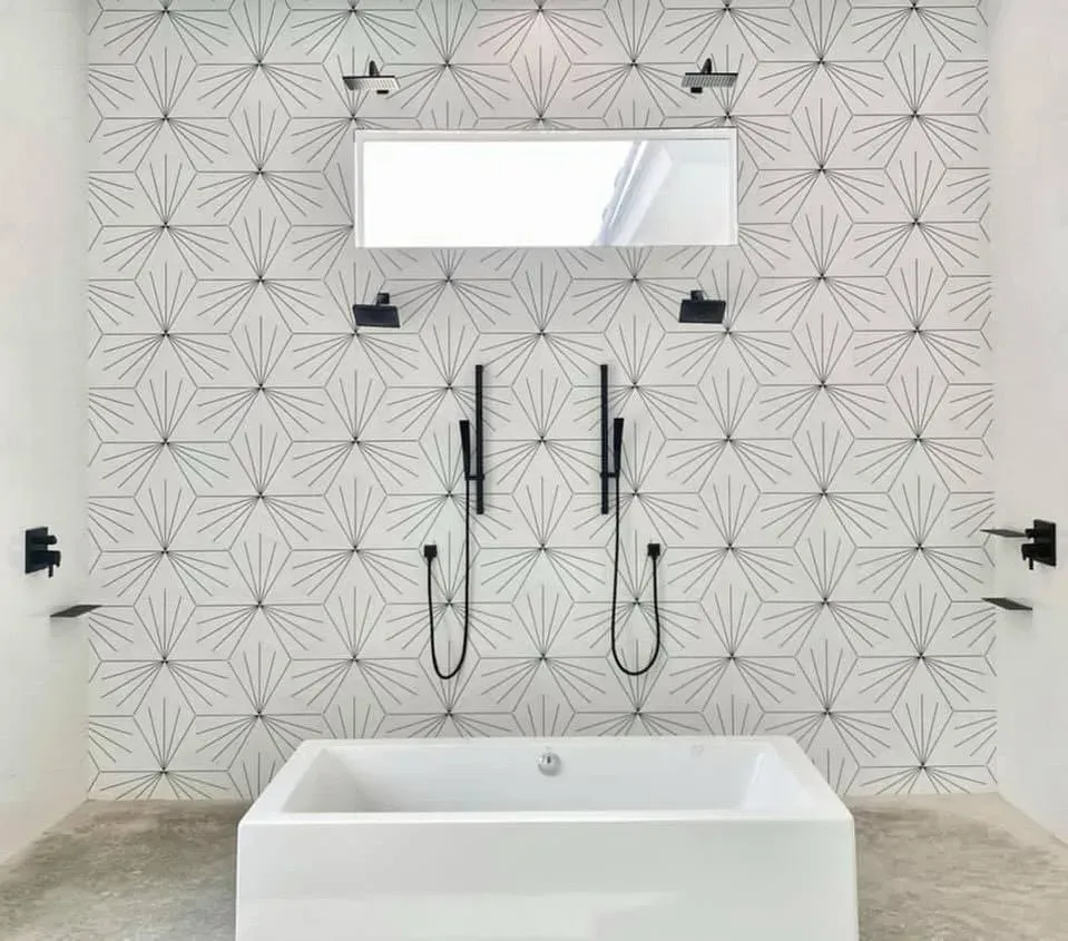 A bathroom with a bathtub , shower and mirror.