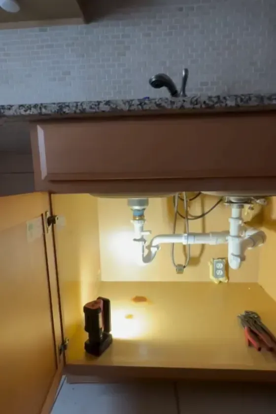 A kitchen sink with a coffee maker underneath it