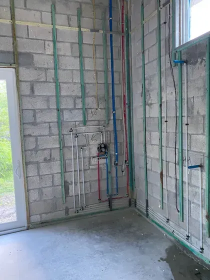 A room with a lot of pipes hanging on the wall.