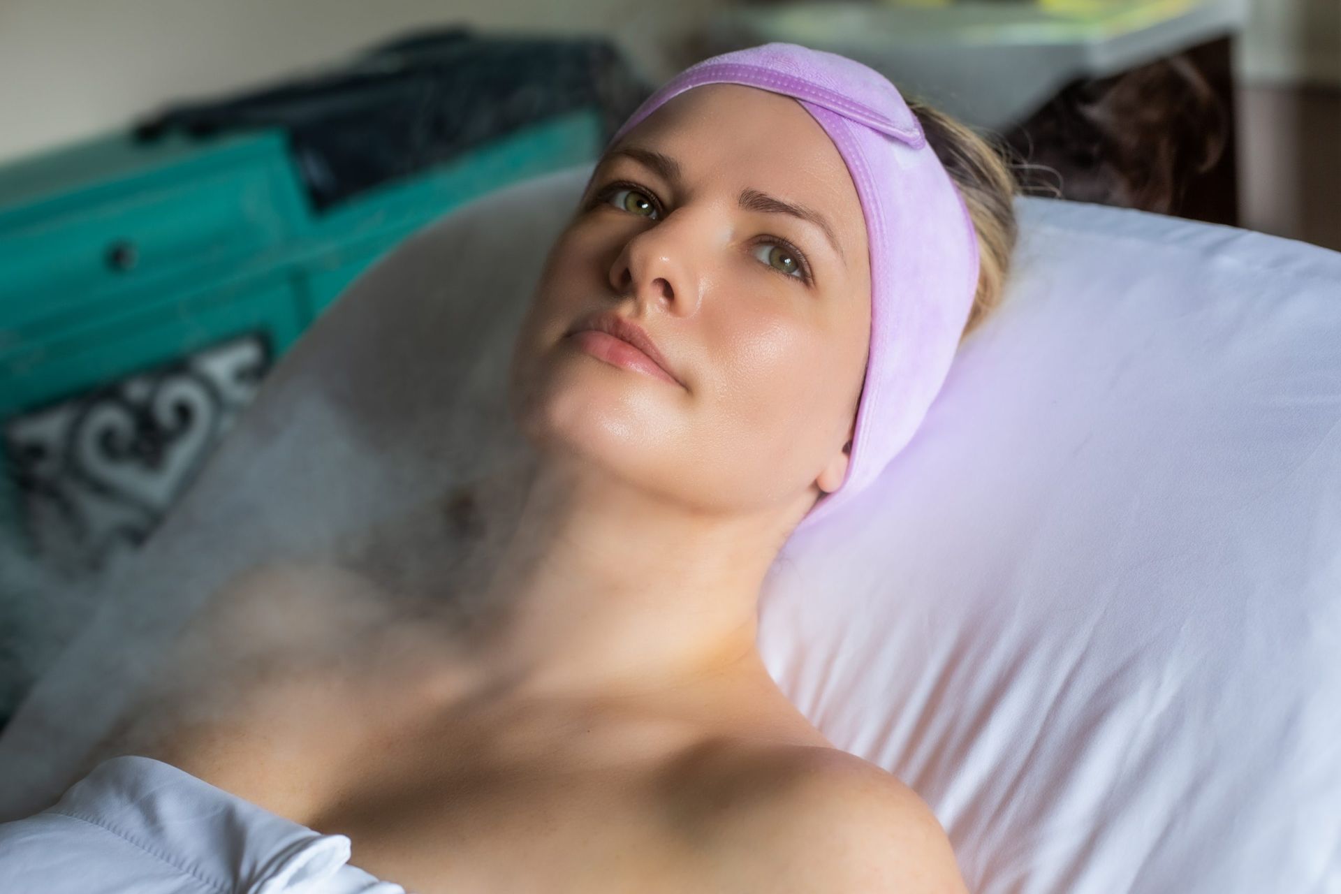 A woman is laying on a bed with a headband on her head.