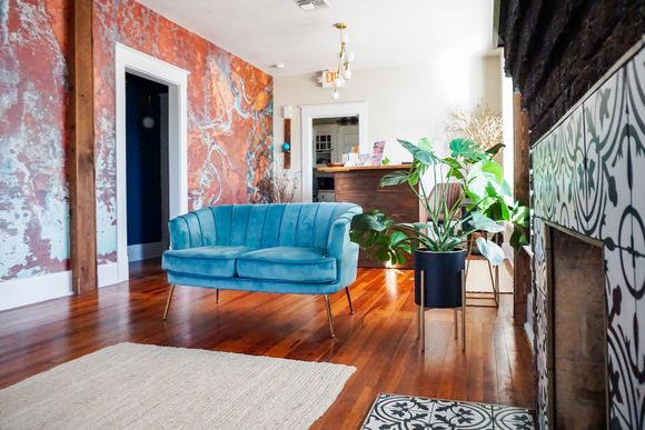 A living room with a blue couch and a fireplace.
