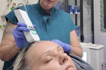 A woman is getting a treatment on her face in a beauty salon.