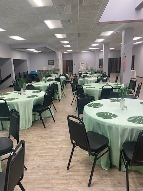 A large room with tables and chairs set up for a party