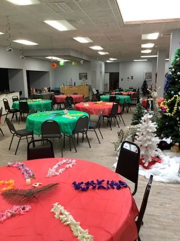 A large room with tables and chairs and a christmas tree