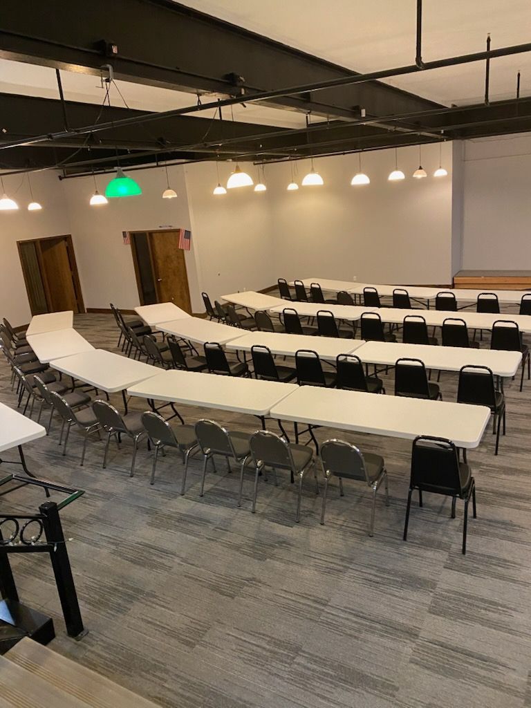 A large room with tables and chairs in it.