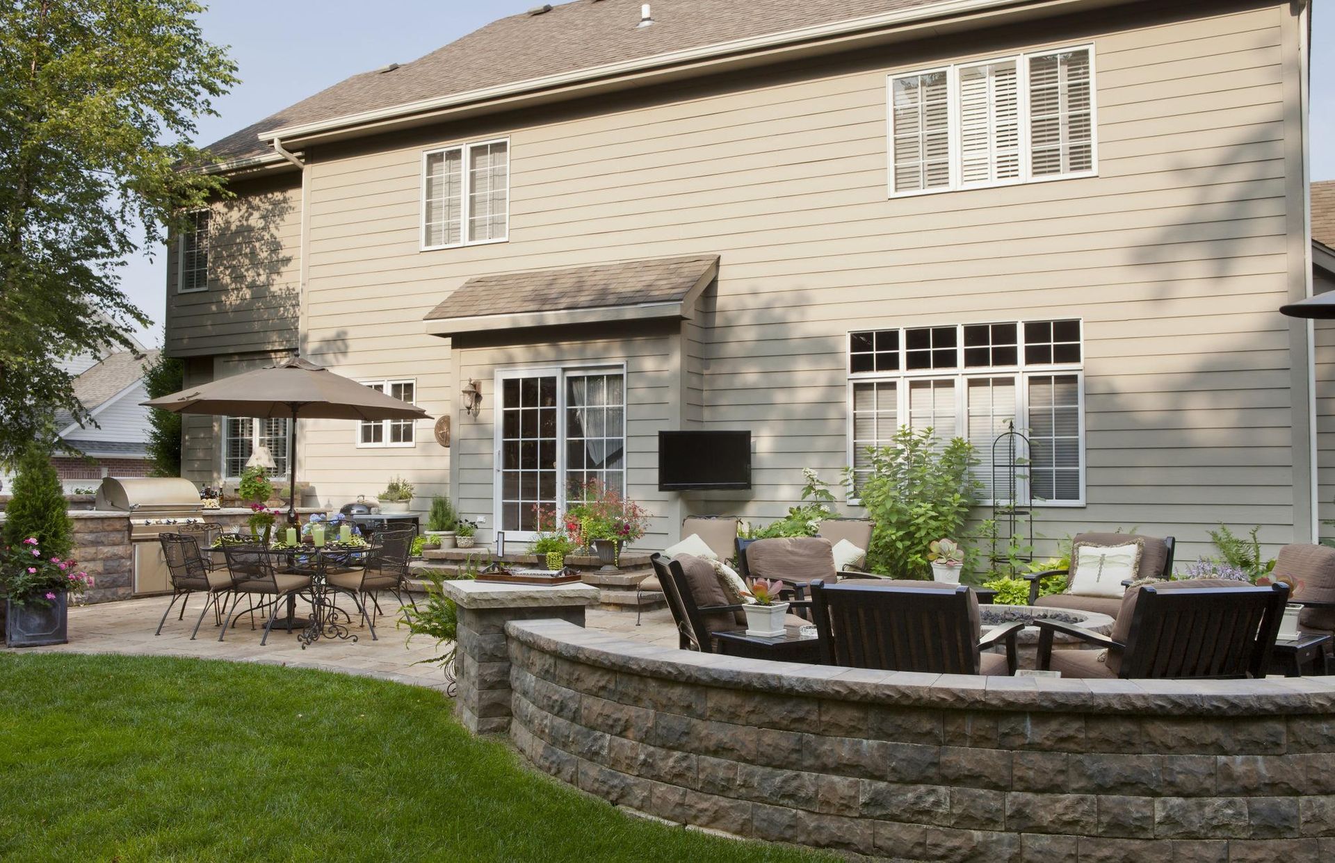 Backyard patio and hardscape in Buffalo Grove IL with seating wall, outdoor dining area, and professionally landscaped yard by Shelly’s Landscape