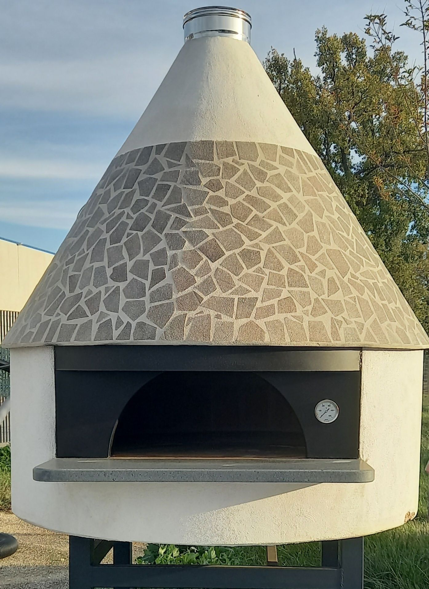 Un grande forno bianco a forma di cono con una porta nera