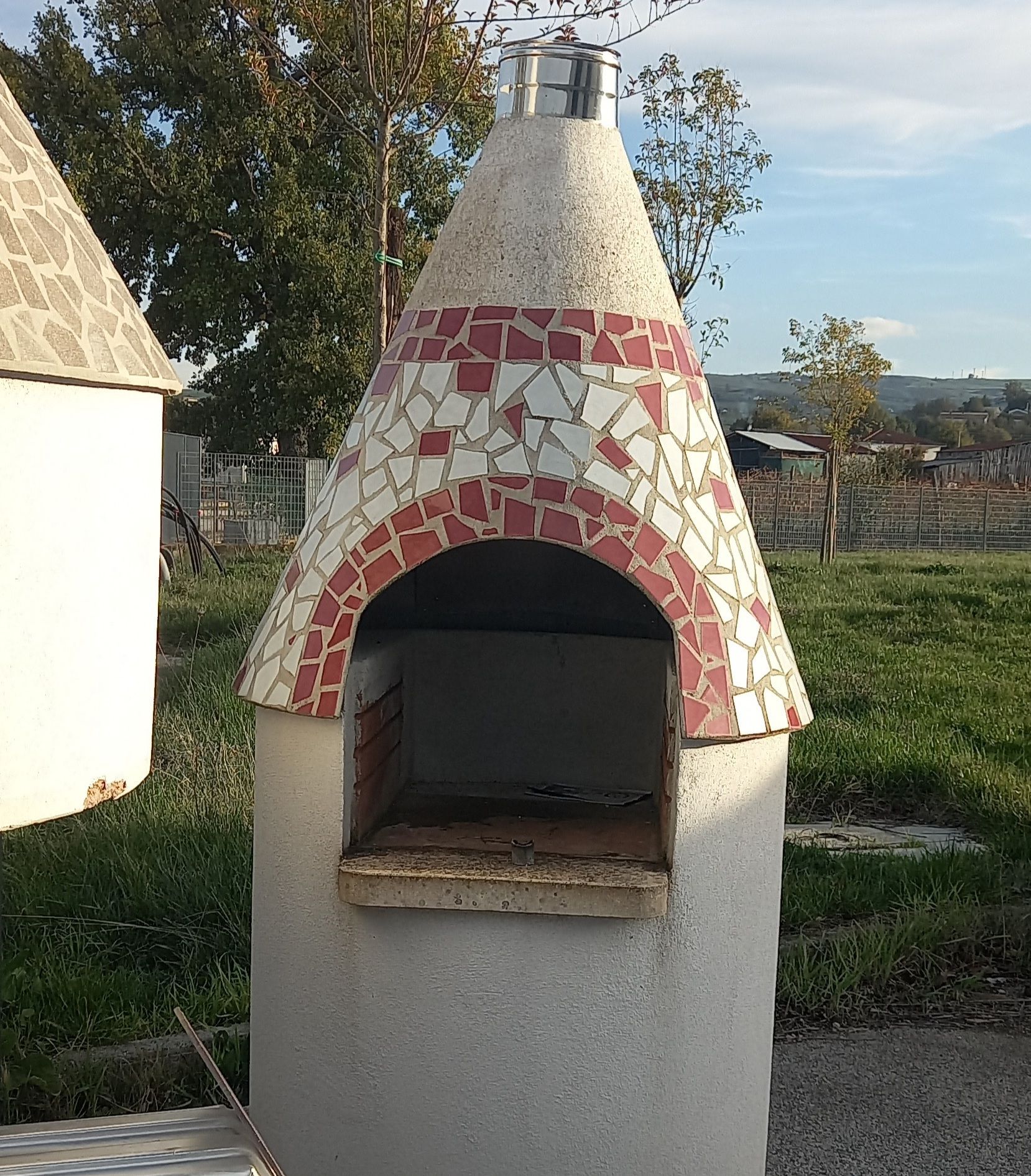 Un piccolo camino in cemento con un tetto di tegole rosse e bianche