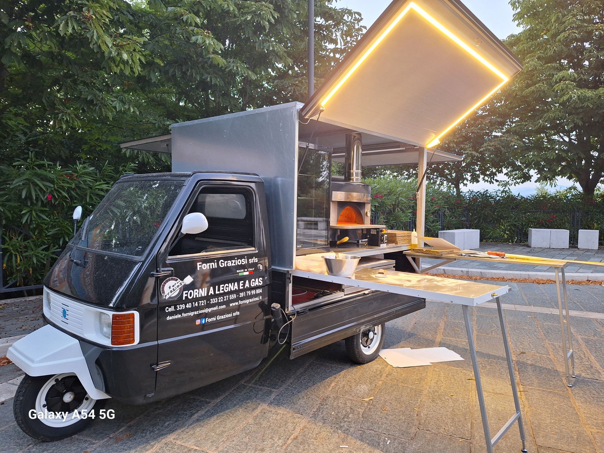 Un camioncino che vende cibo bianco e nero è parcheggiato sul ciglio della strada.