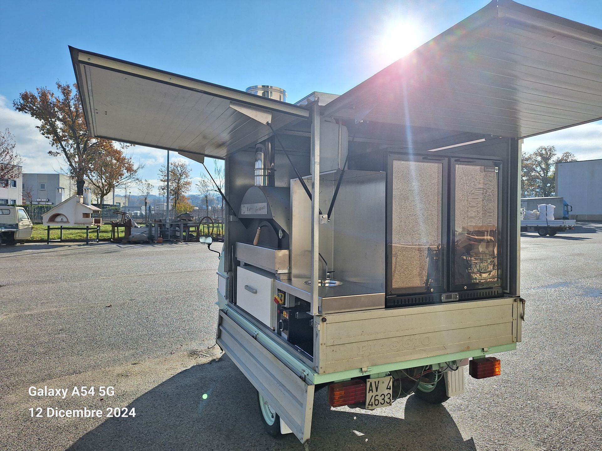 Un camioncino che vende cibo è parcheggiato in un parcheggio con le porte aperte.