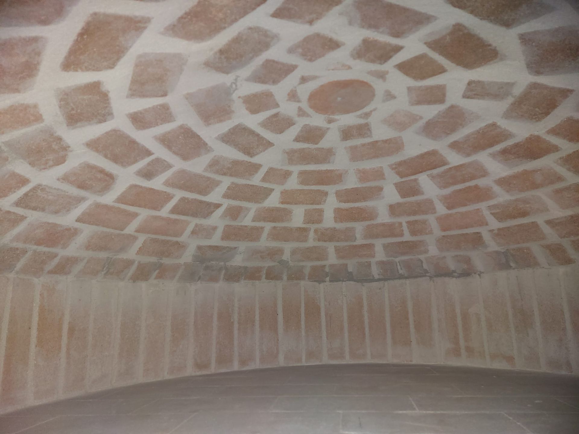 C'è un motivo circolare sul soffitto di un edificio.