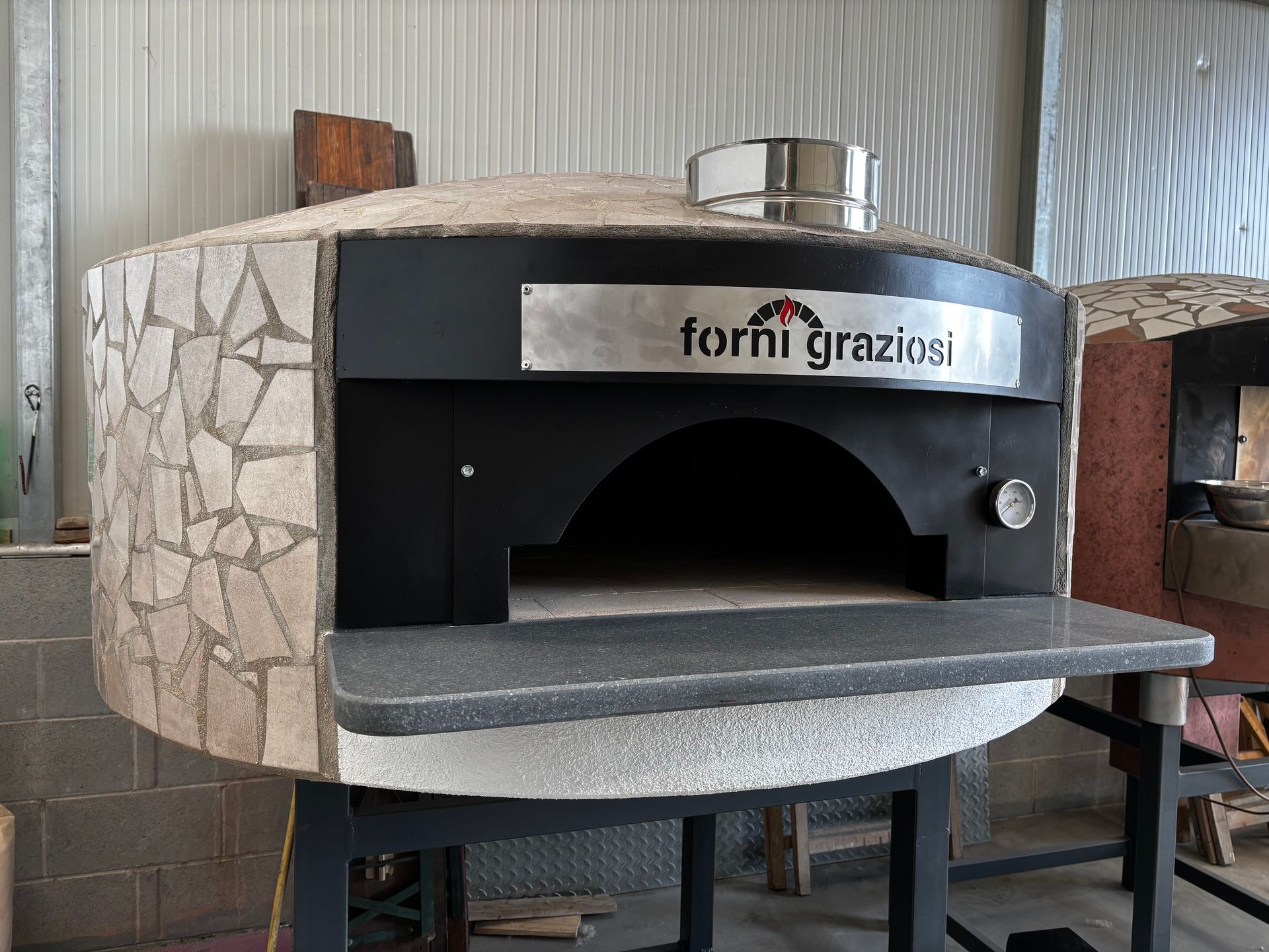 Un forno per pizza con la parola graziosi sopra