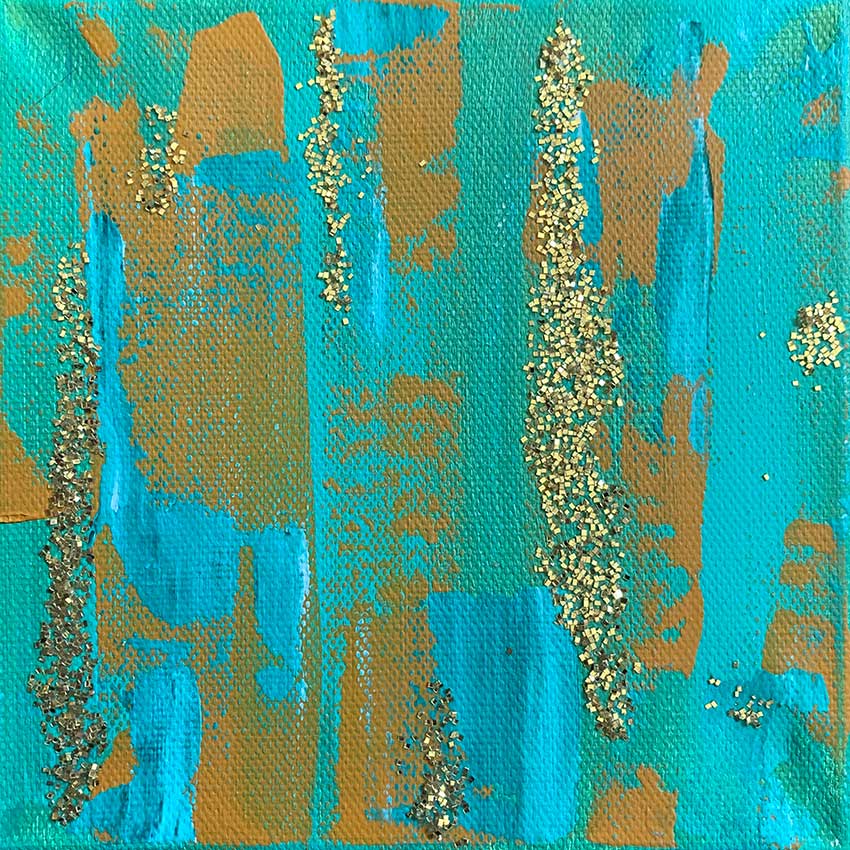 A close up of a turquoise and gold painting on a canvas.