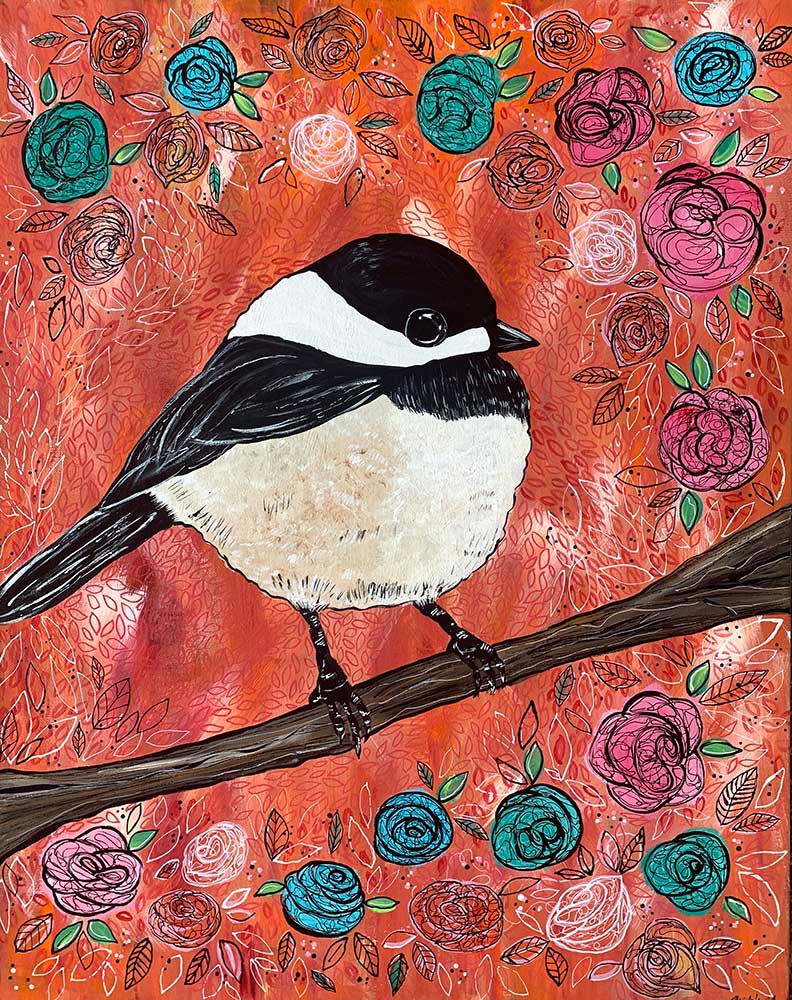 A black and white bird is perched on a branch with flowers in the background.