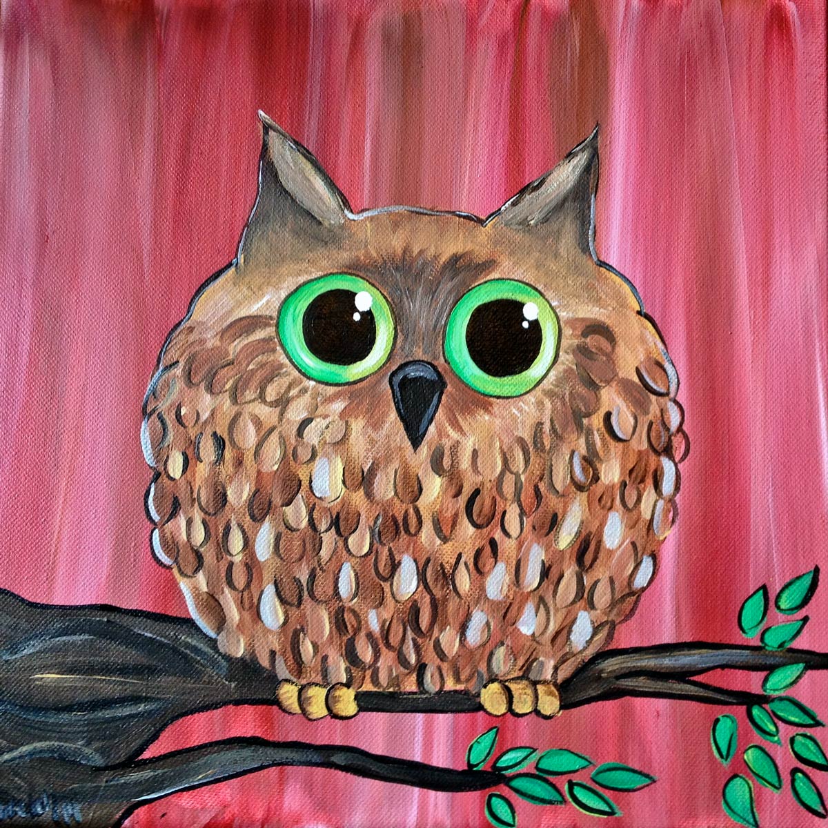 A brown owl with green eyes is sitting on a tree branch