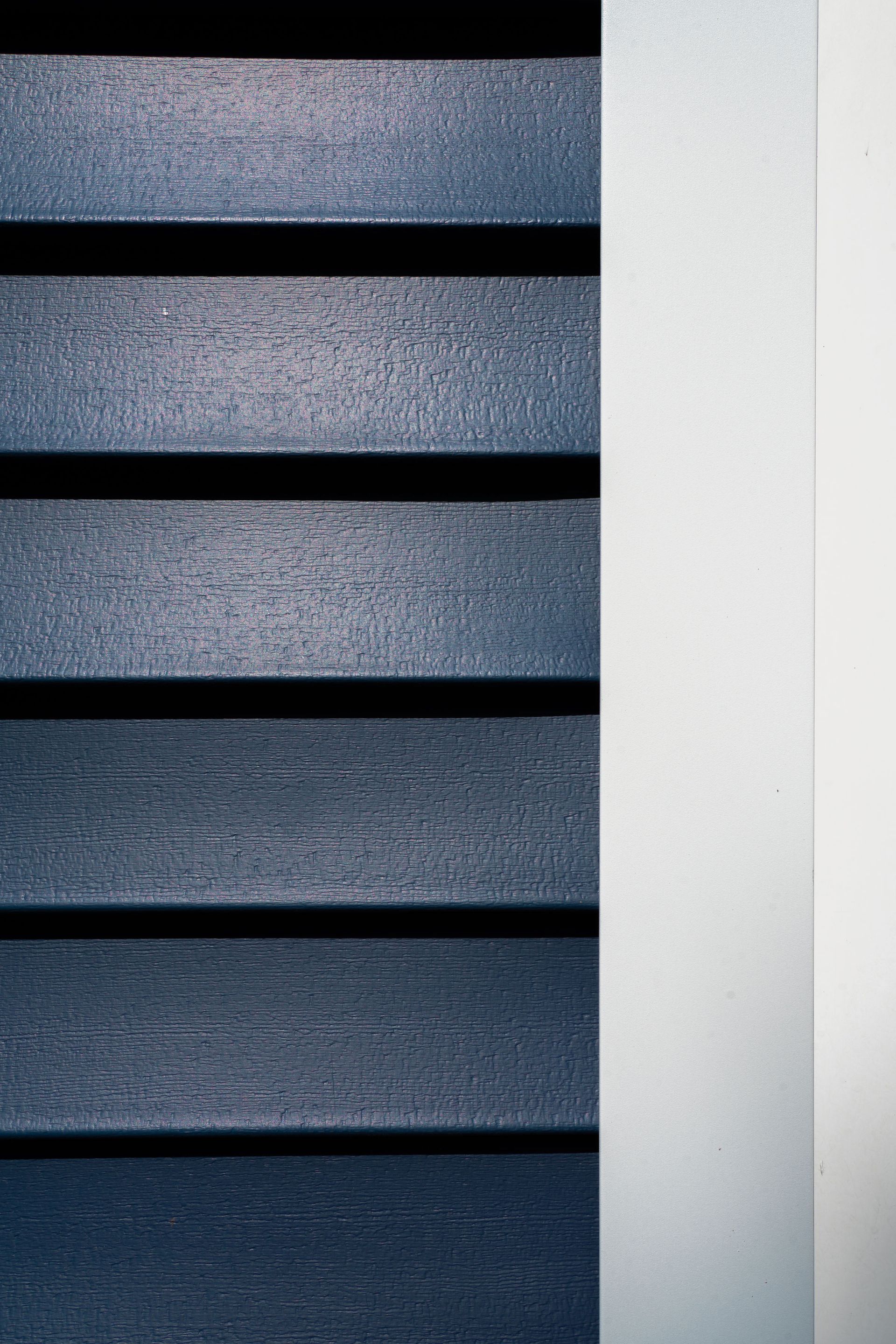 Dark blue horizontal slats to the left, a white vertical strip to the right.